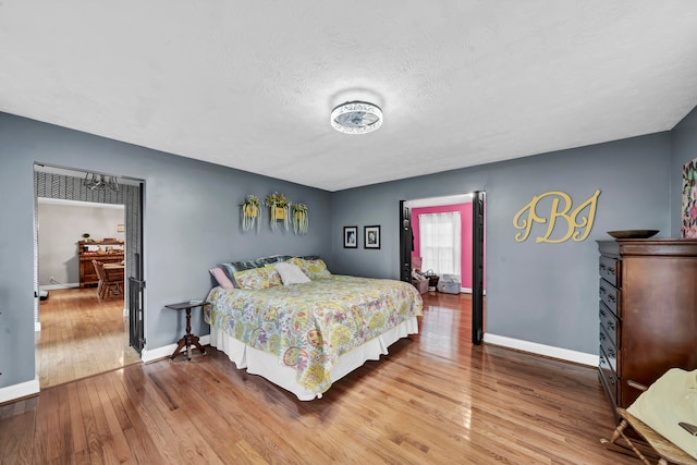 bedroom with a textured ceiling and wood-type flooring