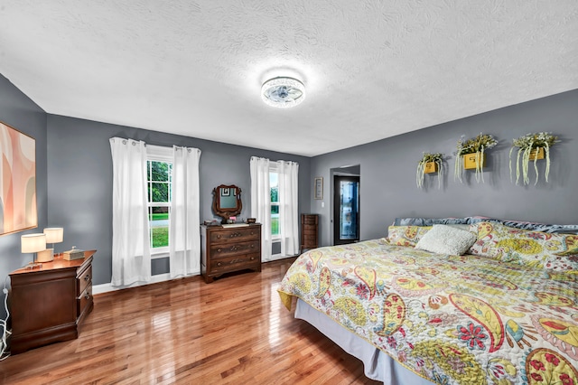 bedroom featuring hardwood / wood-style flooring and a textured ceiling