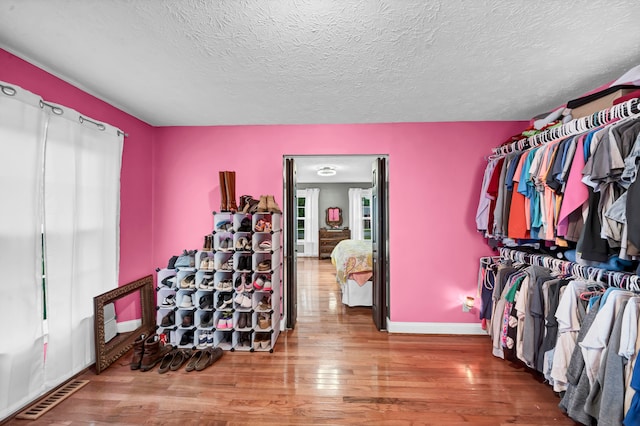 spacious closet with hardwood / wood-style flooring