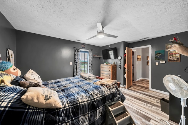 bedroom featuring a textured ceiling, wood-type flooring, and ceiling fan