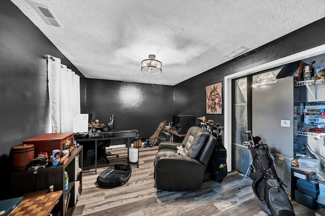 interior space featuring a textured ceiling and hardwood / wood-style floors