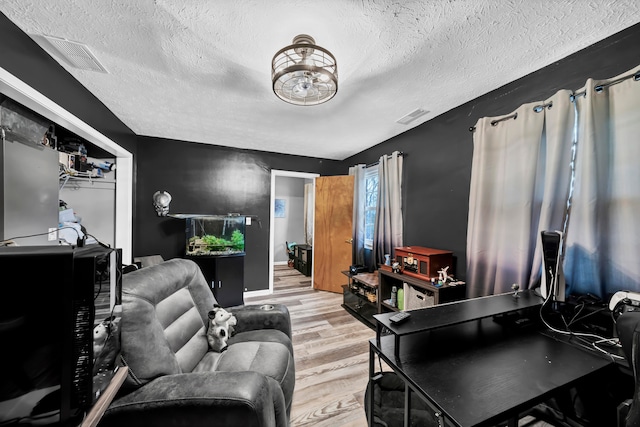 living room featuring a textured ceiling and light hardwood / wood-style flooring