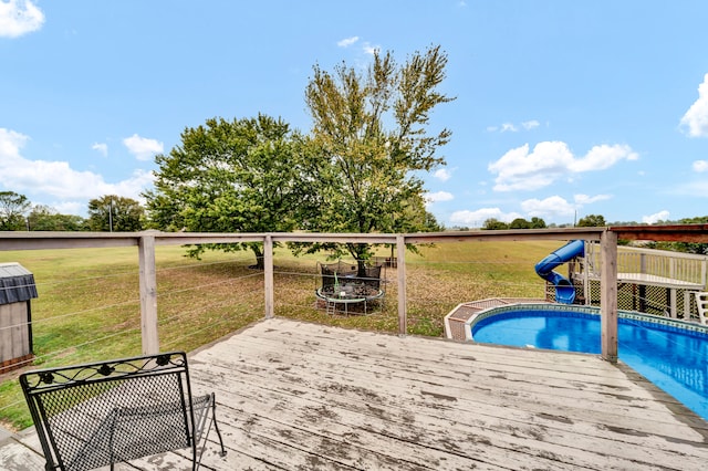 view of swimming pool featuring a deck and a yard