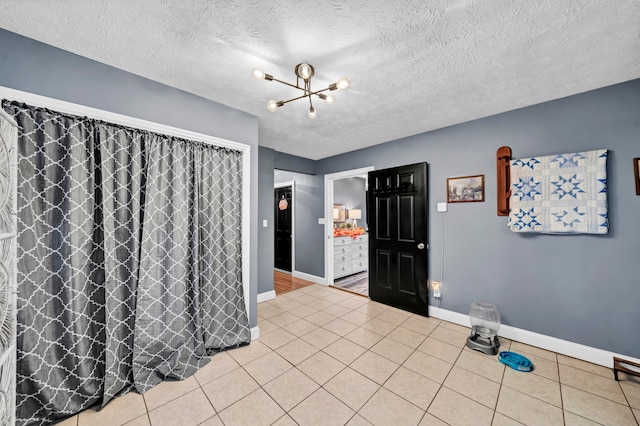 unfurnished room with a textured ceiling and light tile patterned flooring