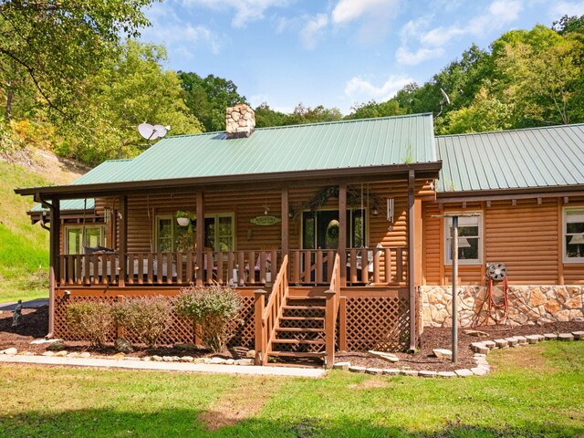 cabin featuring a front lawn and a wooden deck