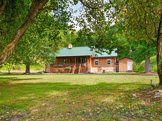 view of front of house with a storage unit, a front lawn, and covered porch