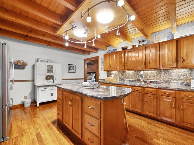 kitchen with light hardwood / wood-style flooring, beam ceiling, and a center island