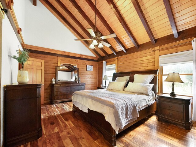 bedroom with multiple windows, wood walls, and hardwood / wood-style floors