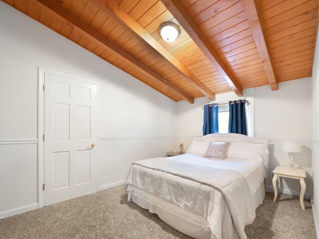 carpeted bedroom with lofted ceiling with beams and wooden ceiling