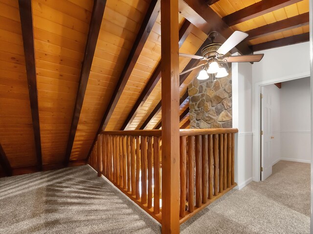 interior space featuring lofted ceiling with beams, wooden ceiling, and carpet flooring