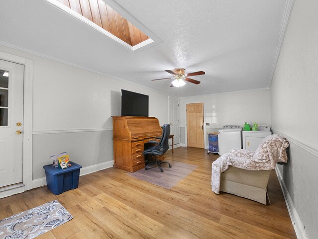 home office featuring light hardwood / wood-style flooring, a skylight, separate washer and dryer, ornamental molding, and ceiling fan