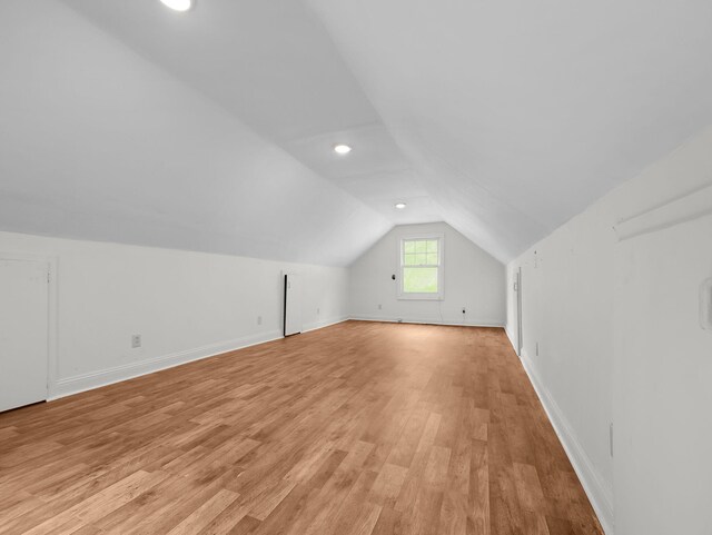 bonus room with vaulted ceiling and light hardwood / wood-style flooring