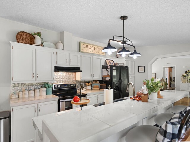 kitchen with white cabinets, stainless steel electric range, and black refrigerator with ice dispenser