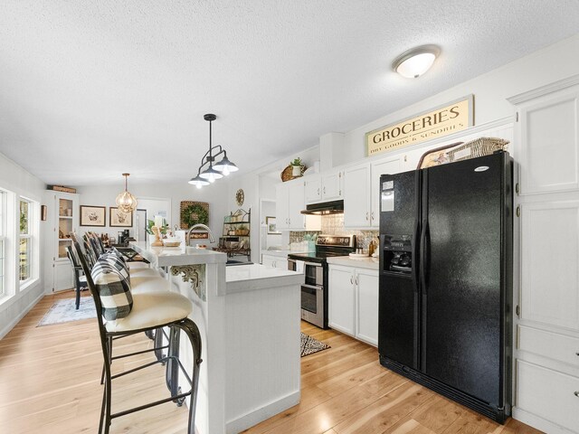 kitchen with white cabinetry, black refrigerator with ice dispenser, light hardwood / wood-style flooring, a kitchen island with sink, and electric range