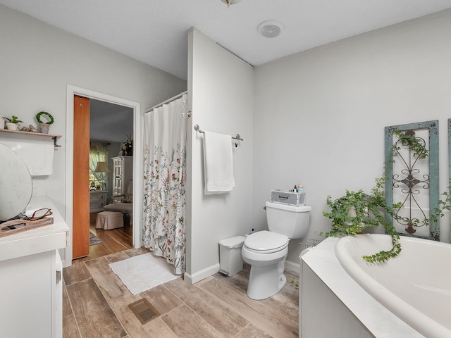 bathroom with hardwood / wood-style floors, toilet, and a washtub