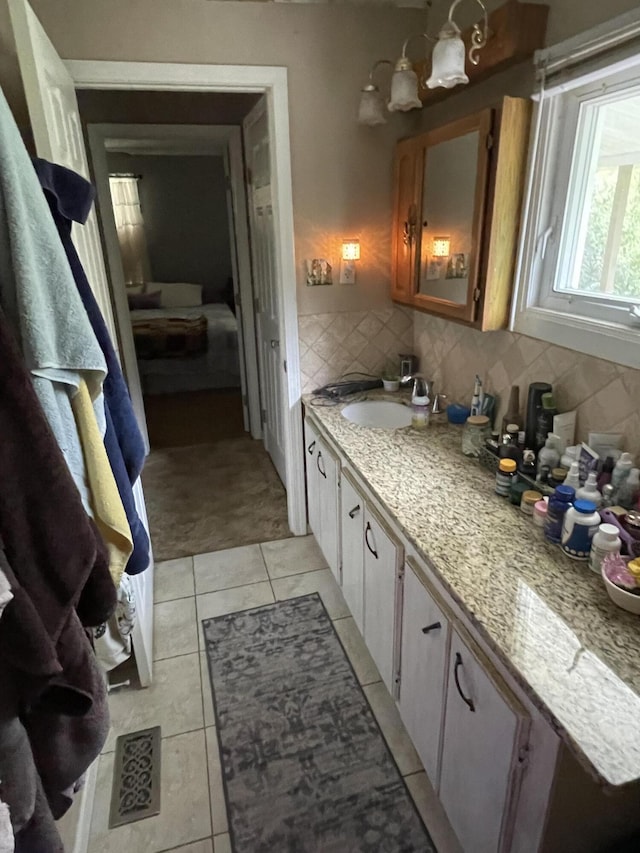 bathroom with decorative backsplash, tile patterned floors, and vanity