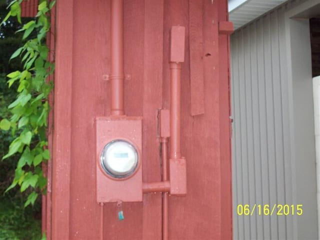 details featuring electric meter and stucco siding
