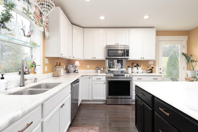 kitchen with dark hardwood / wood-style flooring, white cabinets, stainless steel appliances, and sink