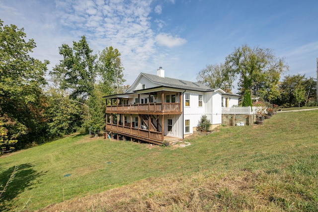 back of property with a lawn and a wooden deck