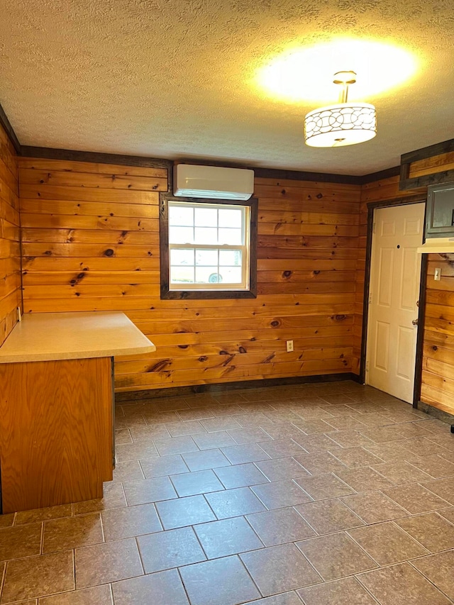 interior space featuring a textured ceiling and wood walls