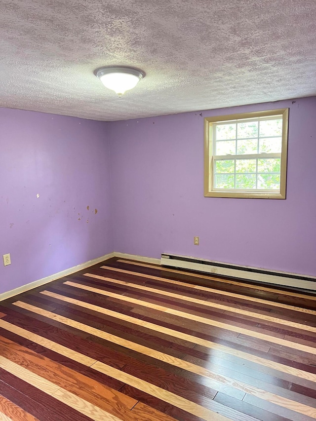 spare room with a textured ceiling, wood-type flooring, and baseboard heating