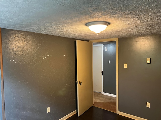 interior space featuring wood-type flooring and a textured ceiling