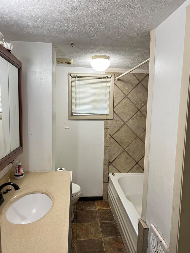 bathroom featuring vanity, toilet, and a textured ceiling