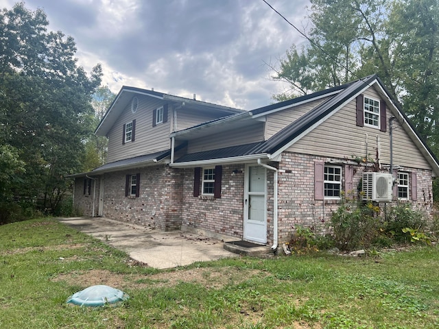 back of property with ac unit, a patio area, and a yard