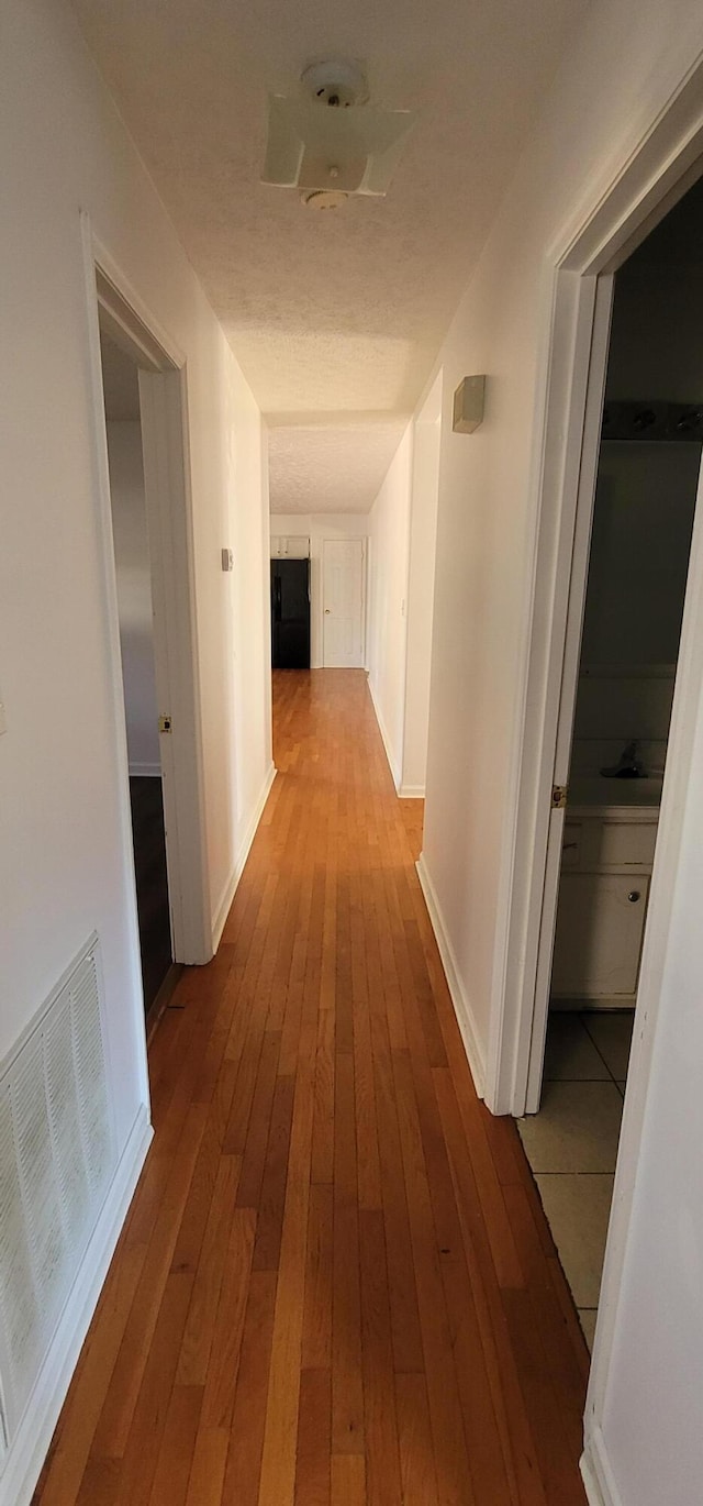 corridor with light hardwood / wood-style flooring