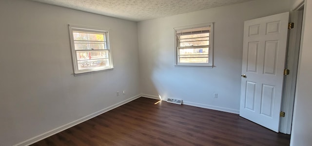 unfurnished room with dark hardwood / wood-style floors and a textured ceiling