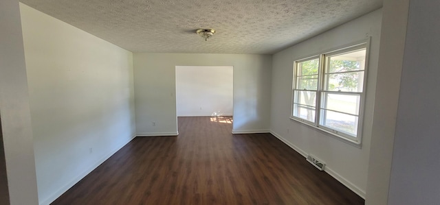 spare room with dark hardwood / wood-style flooring and a textured ceiling