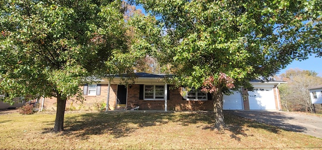 view of property hidden behind natural elements featuring a garage and a front lawn