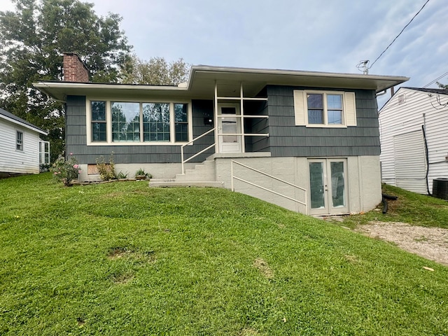 view of front of house featuring a front lawn and central air condition unit