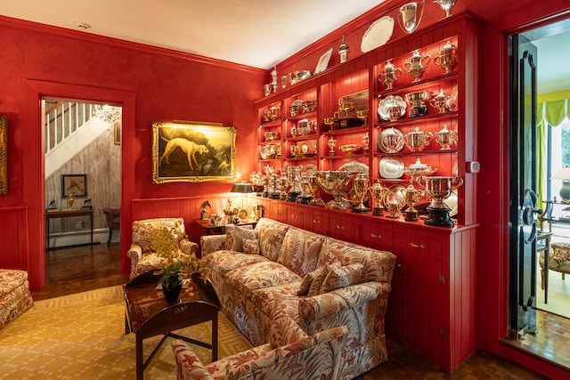 living area with ornamental molding, wood-type flooring, and baseboard heating