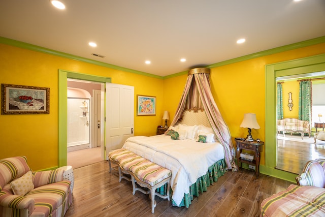 bedroom with ornamental molding and dark hardwood / wood-style flooring