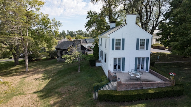 rear view of property with french doors, a yard, and a patio area