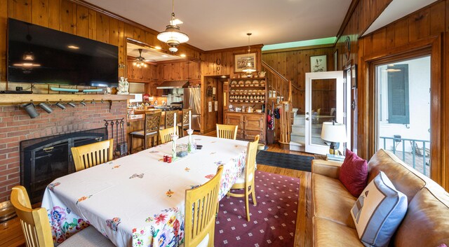3521 Bryan Station Rd, Lexington, KY 40516 - dining space featuring wooden walls, stairway, wood finished floors, ceiling fan, and a fireplace
