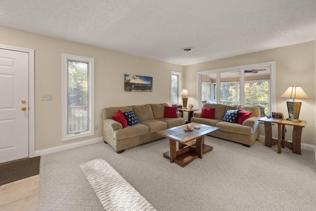 living room with a textured ceiling, light colored carpet, and a wealth of natural light