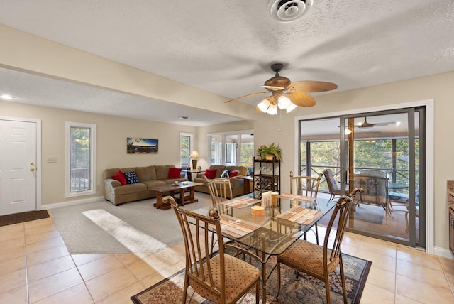 tiled dining space featuring a textured ceiling and ceiling fan