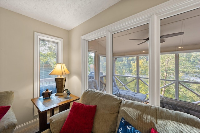 living room with a textured ceiling and ceiling fan