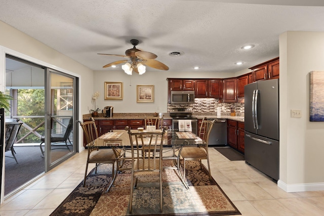 kitchen with appliances with stainless steel finishes, light tile patterned floors, a textured ceiling, and ceiling fan