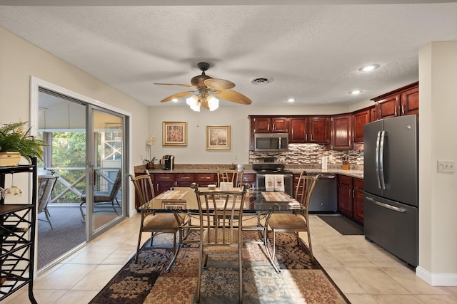 kitchen with ceiling fan, a textured ceiling, stainless steel appliances, and light tile patterned flooring