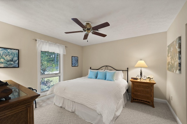 carpeted bedroom featuring a textured ceiling and ceiling fan