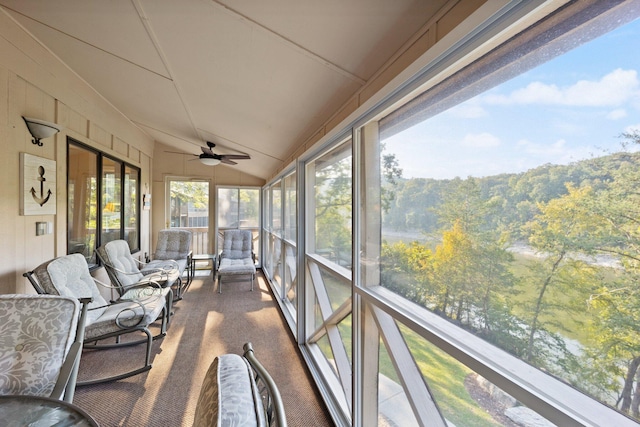 sunroom / solarium featuring ceiling fan, lofted ceiling, and a water view