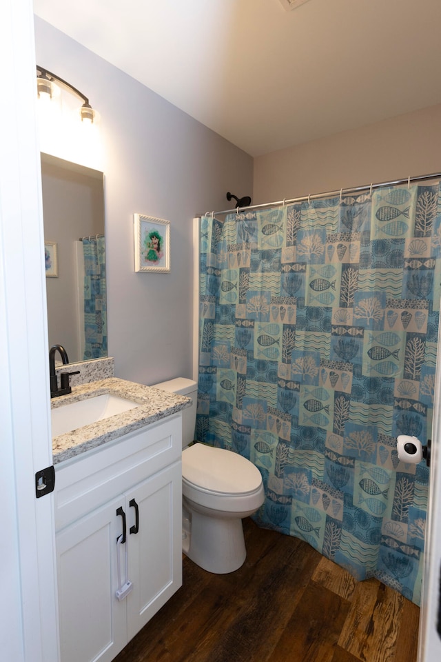 bathroom featuring curtained shower, vanity, hardwood / wood-style flooring, and toilet