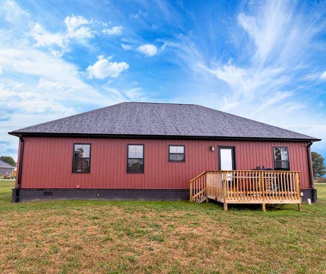 rear view of property featuring a lawn and a deck