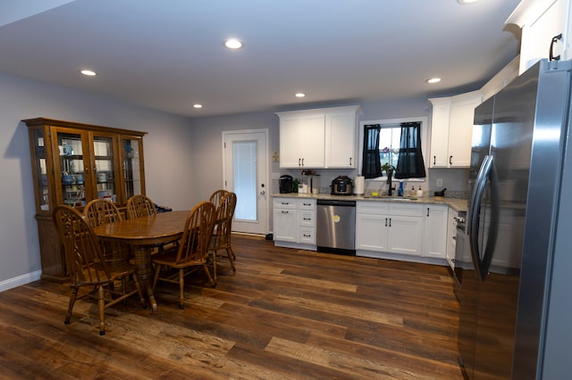 kitchen featuring dark hardwood / wood-style flooring, light stone countertops, white cabinets, and stainless steel appliances