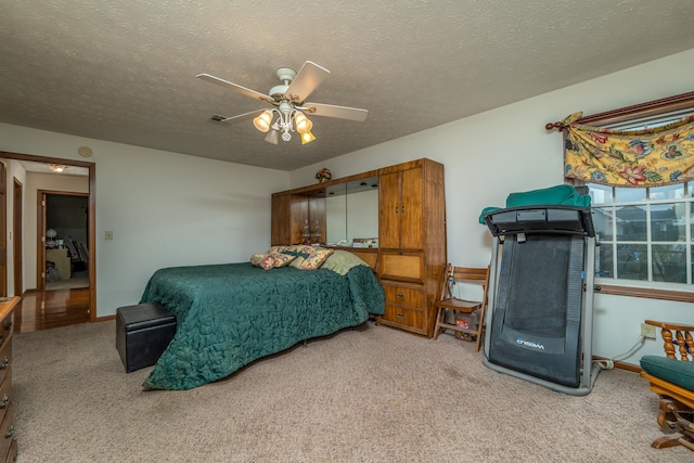 carpeted bedroom with ceiling fan and a textured ceiling