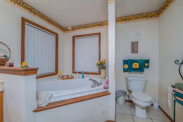 bathroom with a textured ceiling, tile patterned floors, toilet, and a tub