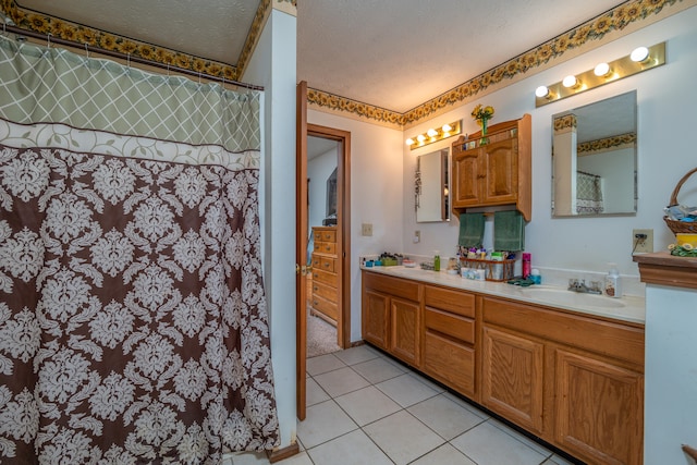 bathroom with a textured ceiling, tile patterned flooring, and vanity